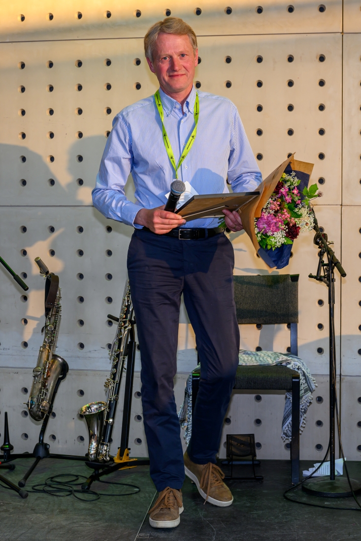 Man med skjorta och blombukett.