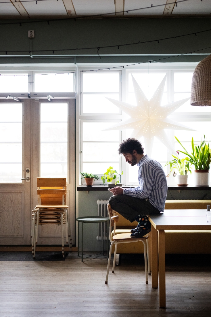 Man på stol i ljust rum.