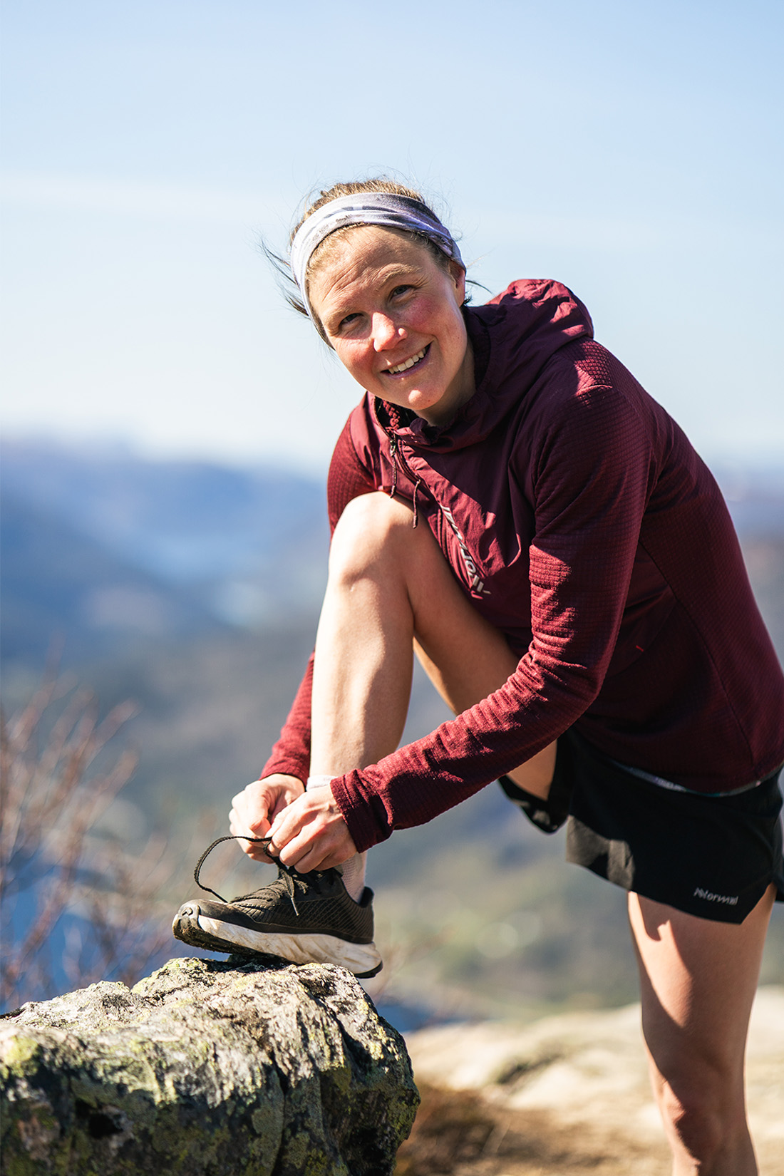 Löparen Emelie Forsberg knyter skorna på en sten.