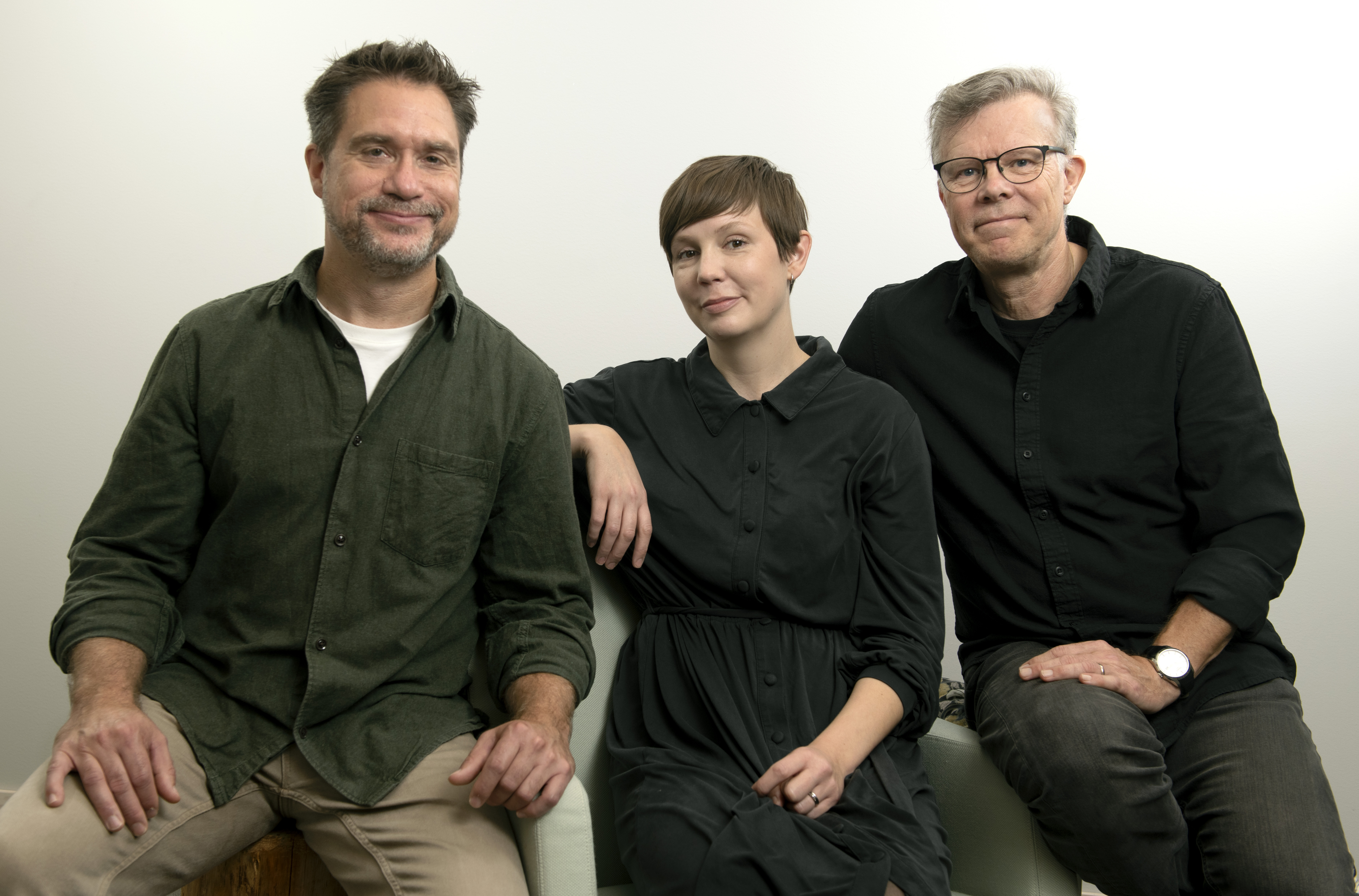 Två män och en kvinna som sitter.