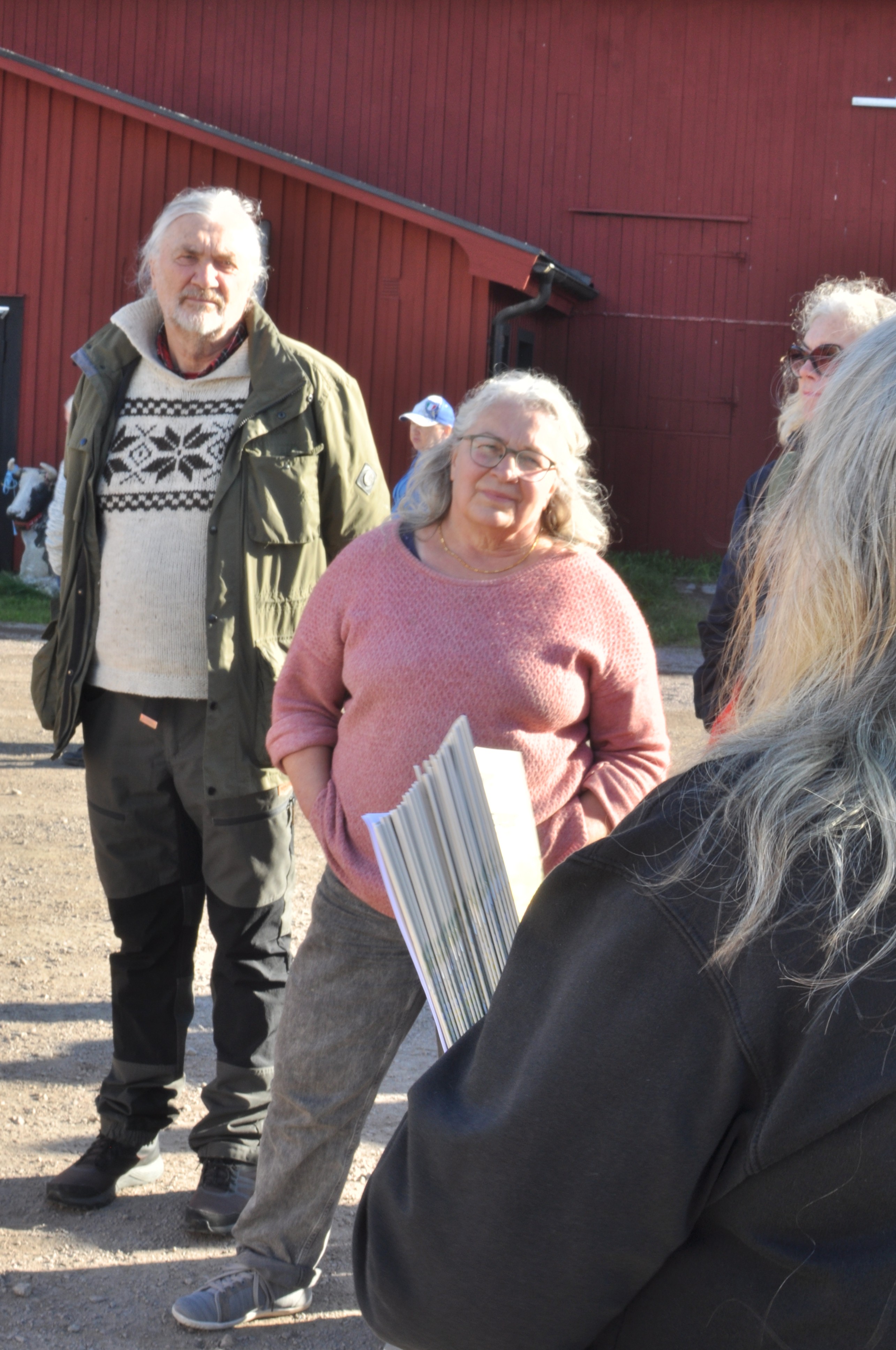 Man och kvinna på gård lyssnar.