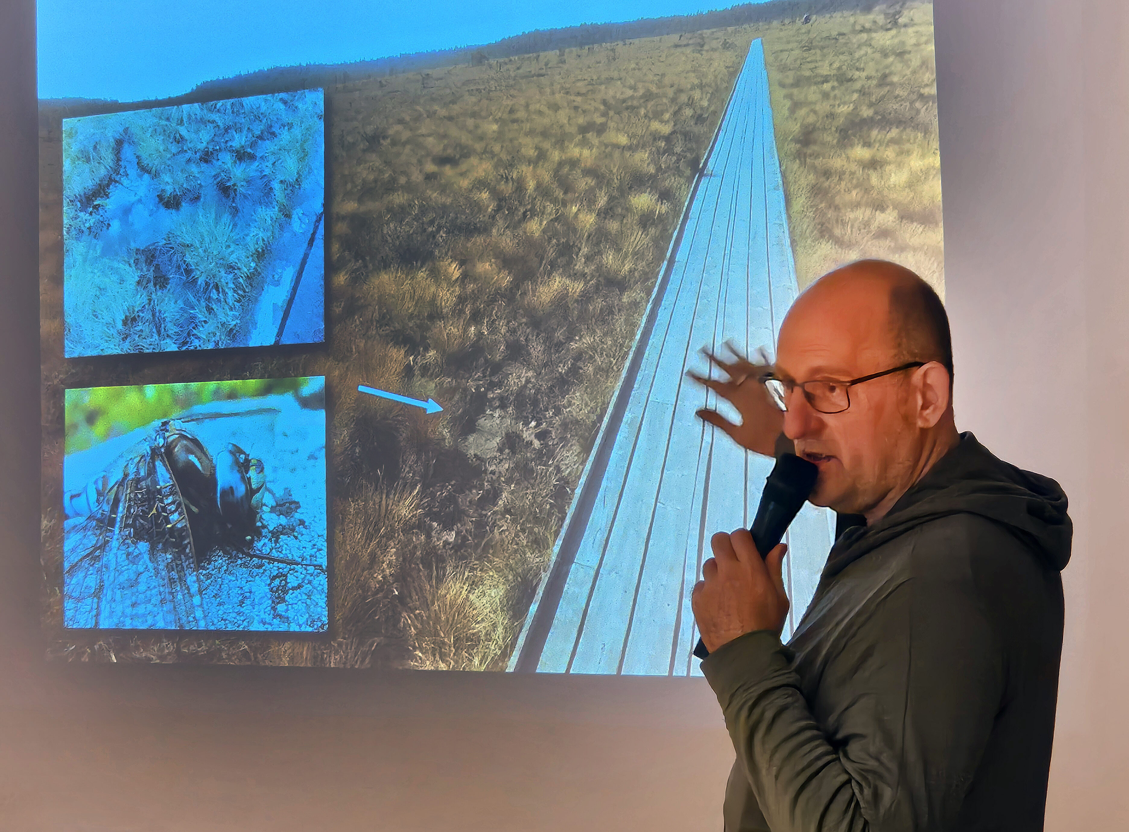 Man framför skärm på scen