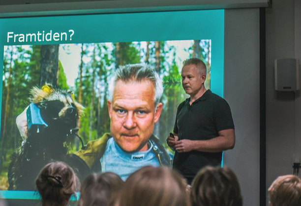 Man håller föredrag på scen.