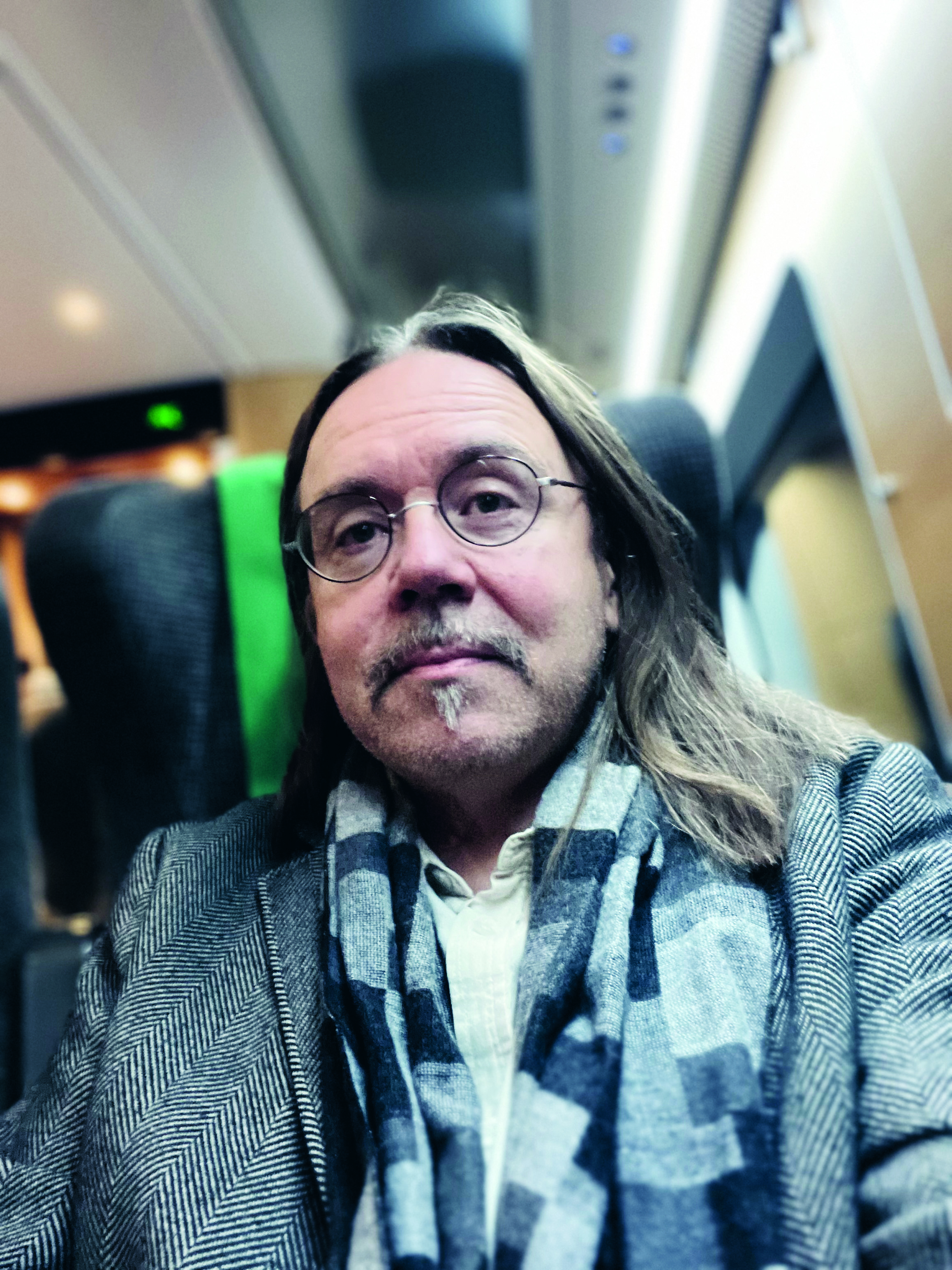 Man med långt hår och glasögon.