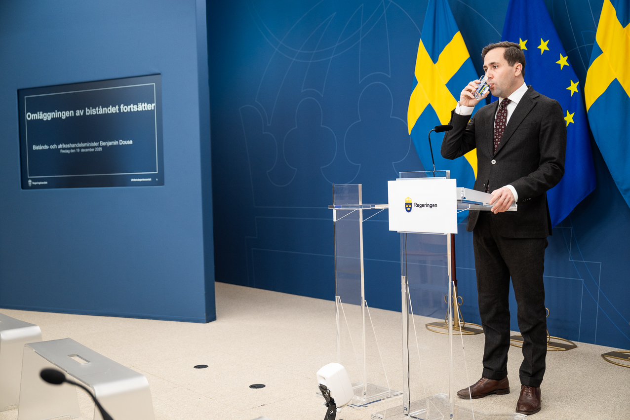 Man i kostym vid podium.