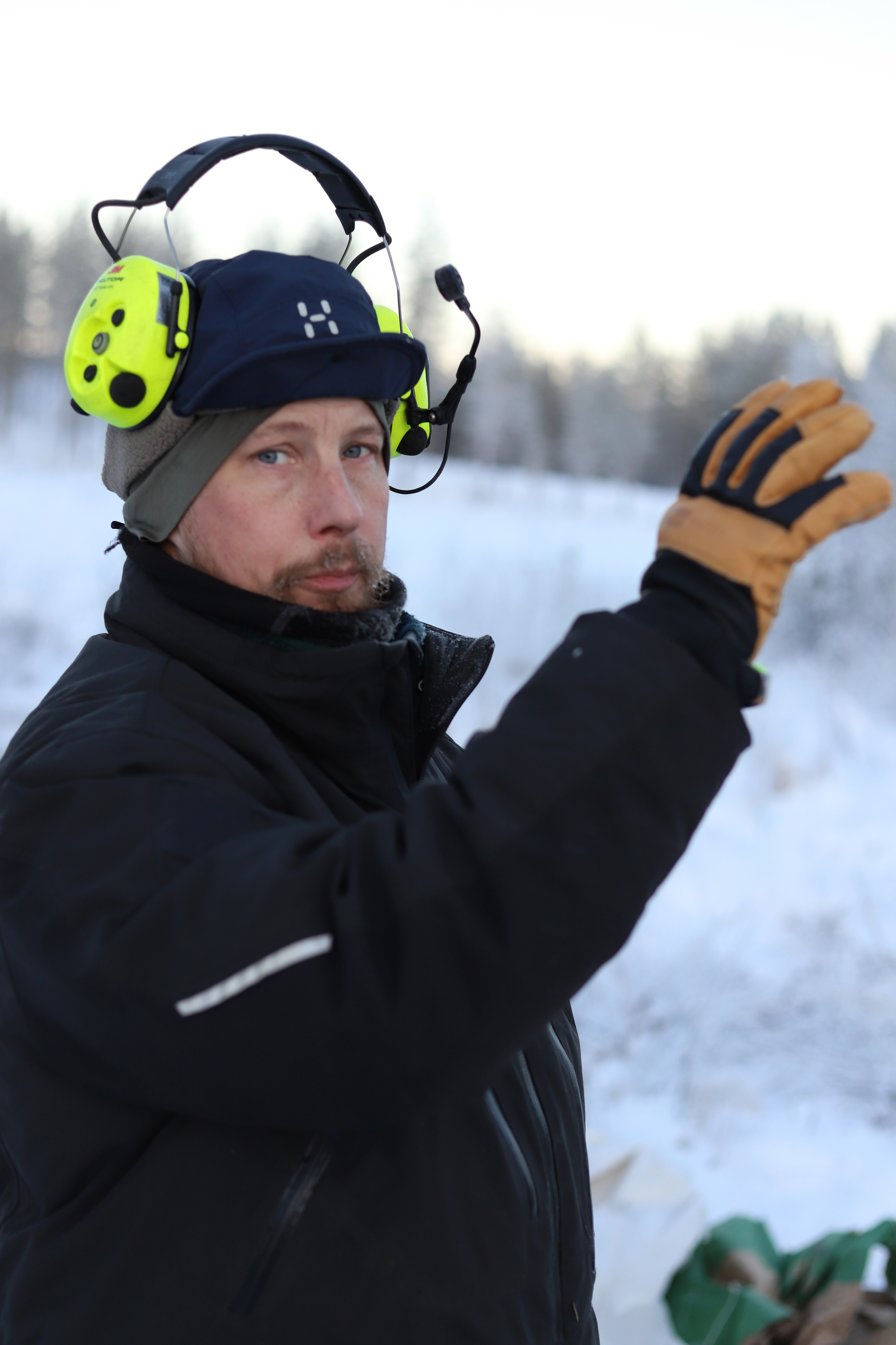 Men med mössa och hörselskydd i snö.