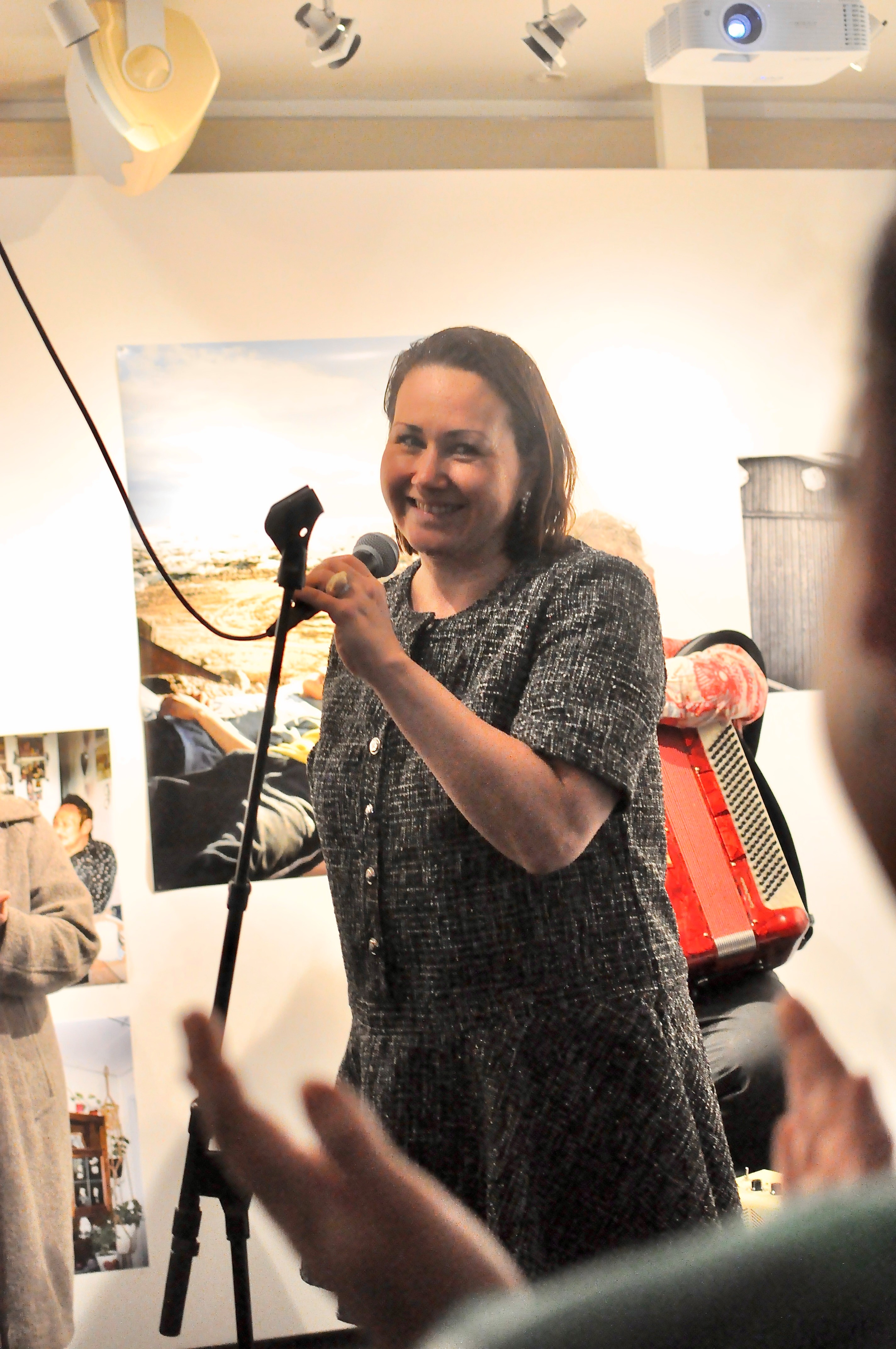 Kvinna i dräkt vid mikrofon.