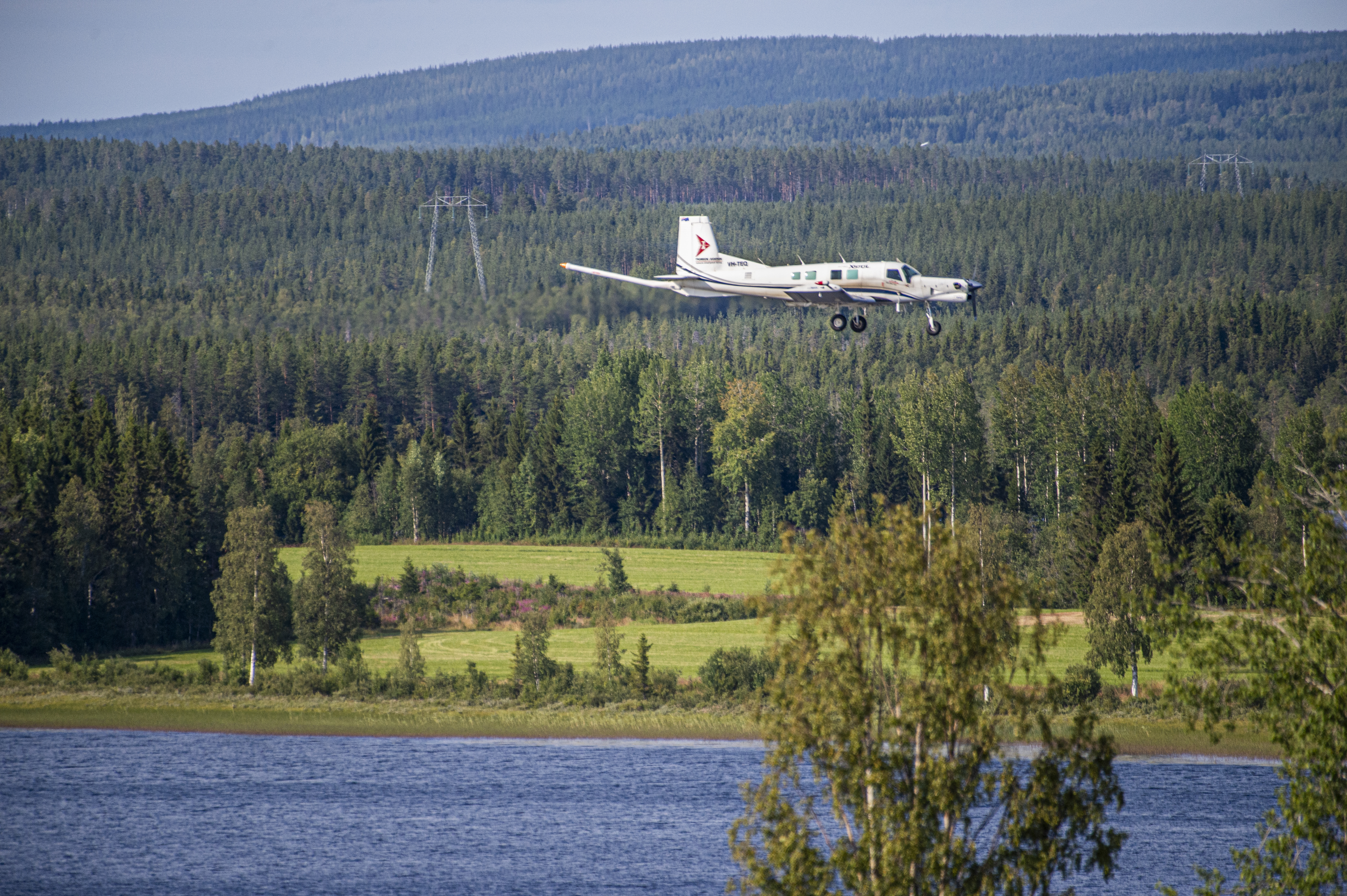 Flygplan över sjö och skog.
