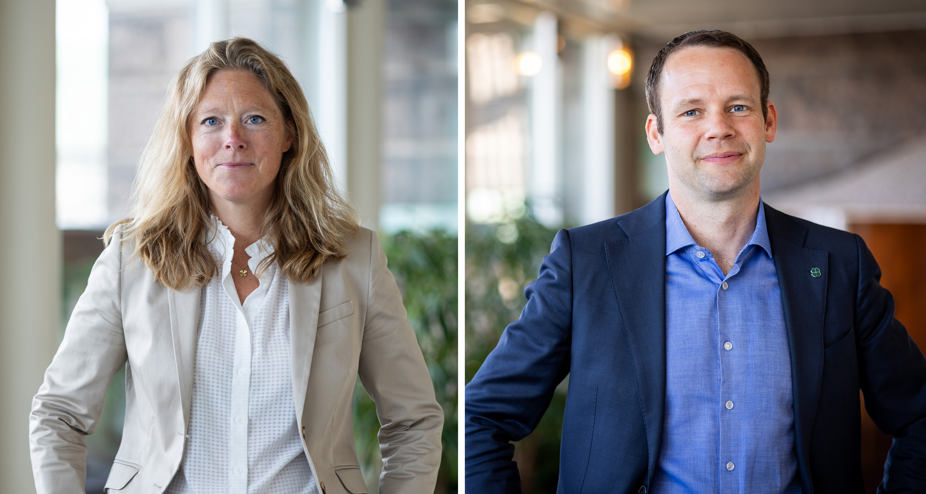 Två personer står inomhus; en kvinna i blazer och vit skjorta till vänster, en man i mörk blazer och blå skjorta till höger. Båda ser mot kameran.