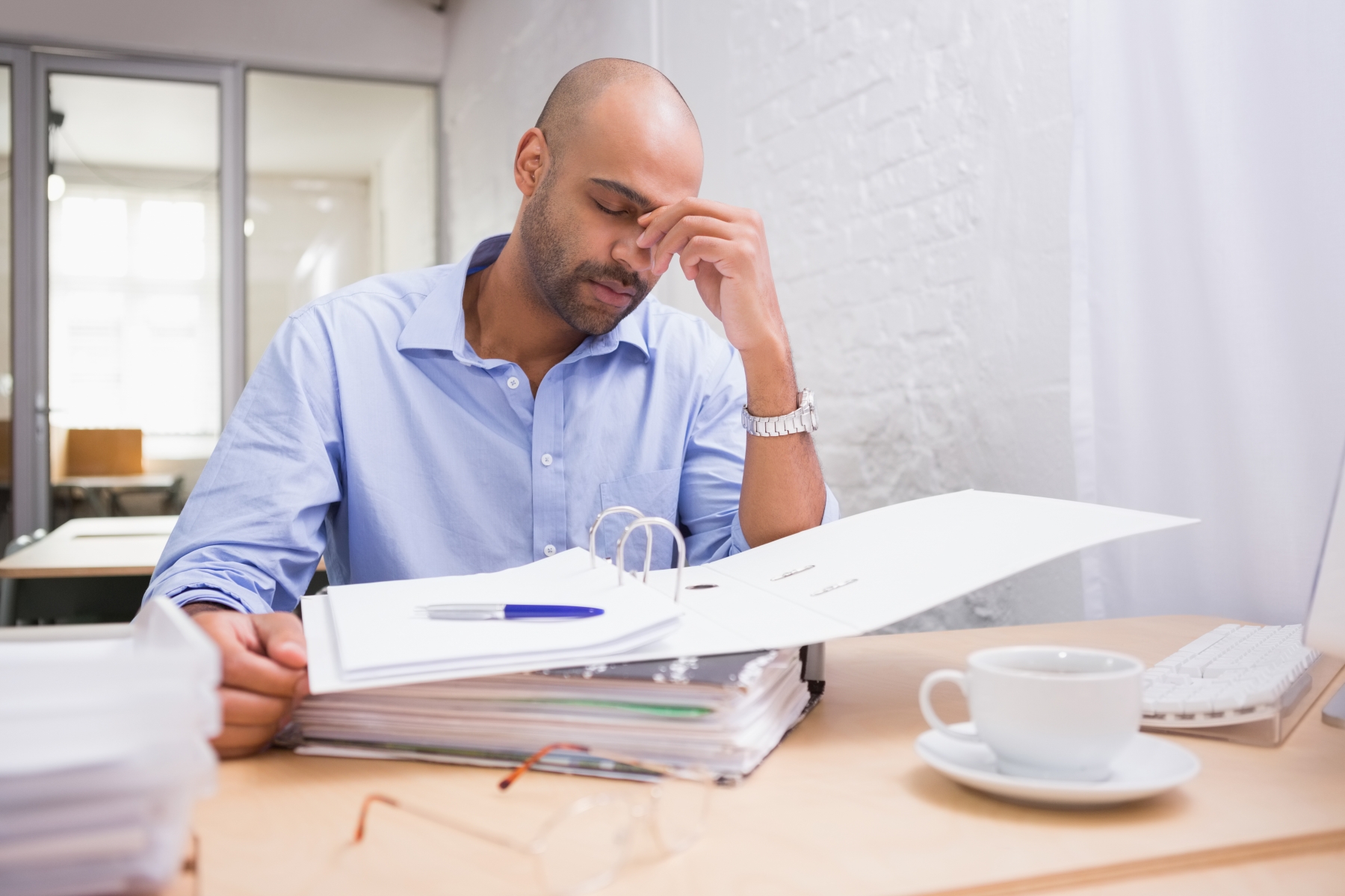 10215730-tired-businessman-with-paperwork-at-desk_kopia