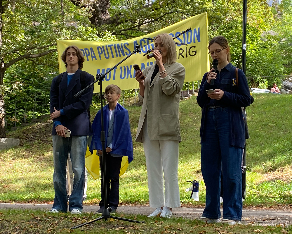 Olena Parinova och sönerna Dmytro och Ivan håller tal under manifestationen mot Putins krig i Ukraina.