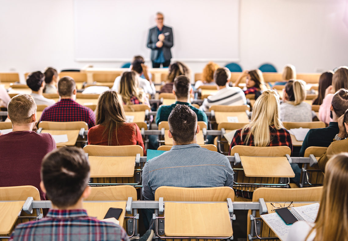 En stor grupp studenter i en föreläsningssal.
