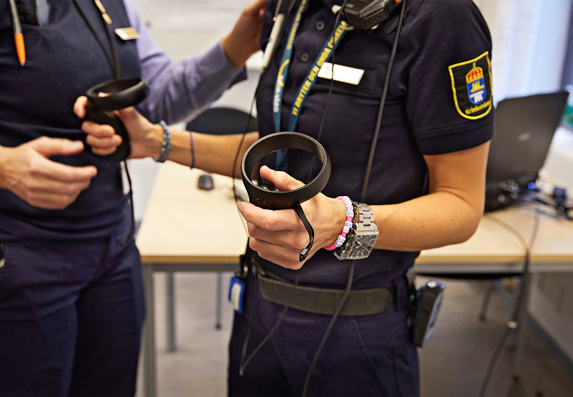 Den som tränar med VR-glasögon håller i handkontroller som styr rörelserna i den virtuella världen.