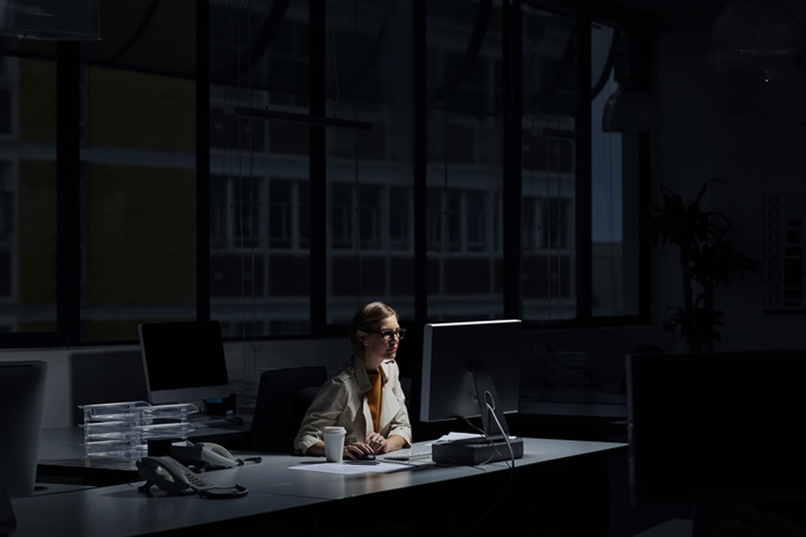 Ung kvinna jobbar sent på kontoret.
