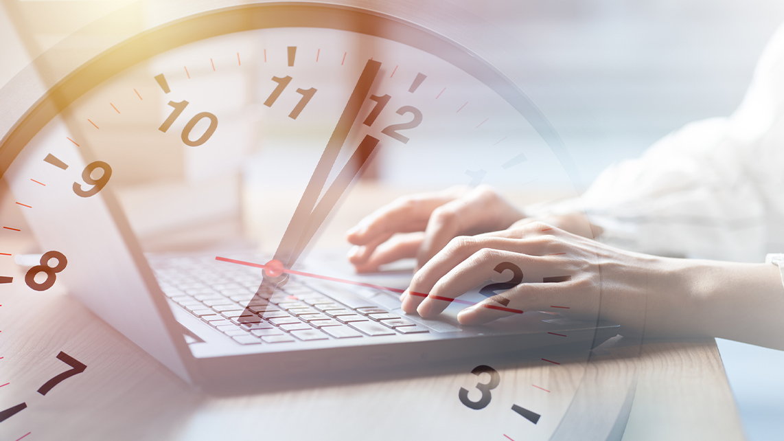 En klocka och arbetare vid datorn för att illustrera mertid.