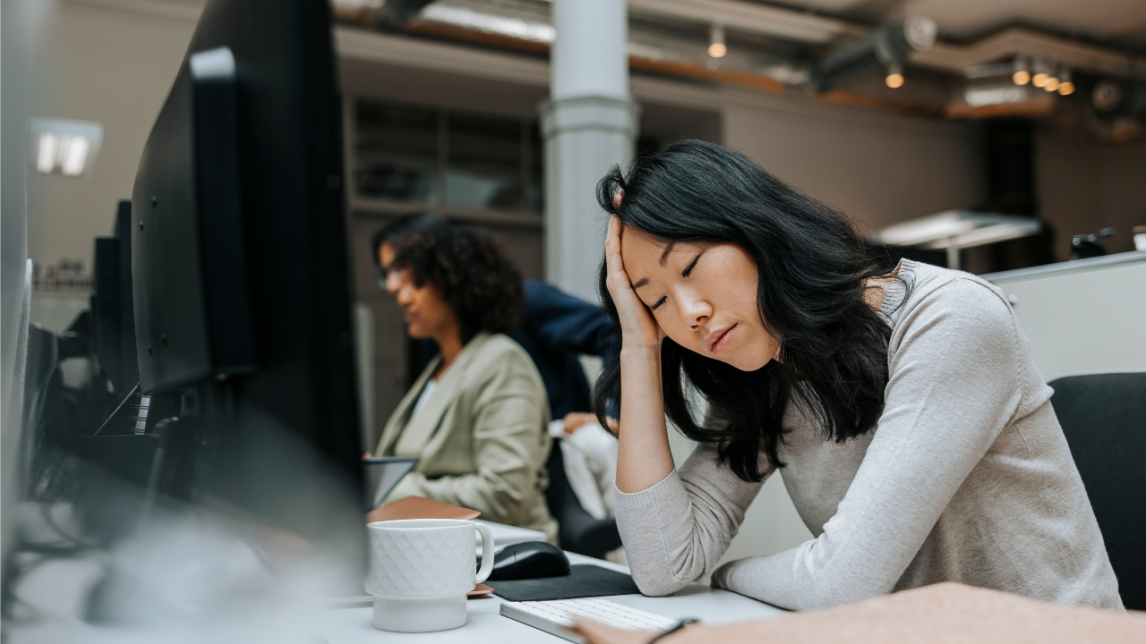 En utmattad kvinna i kontorslandksap.