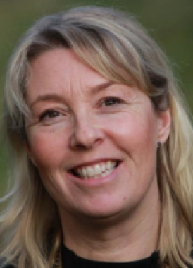 Anna Gordh med blont hår ler mot kameran.