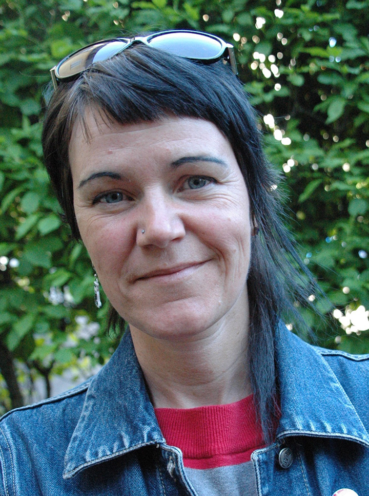 Jessika Spångberg med solglasögon på huvudet, utomhus framför grönska.