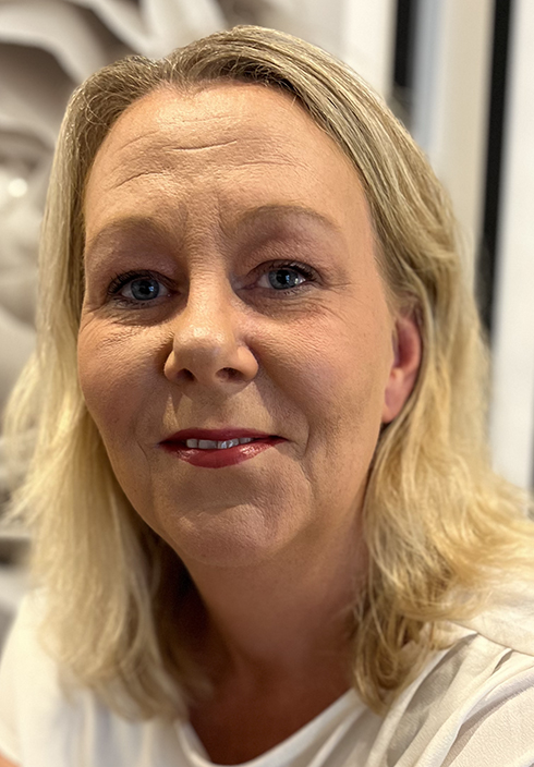 Madeleine Hügel med axellångt blont hår och blå ögon tittar mot kameran.