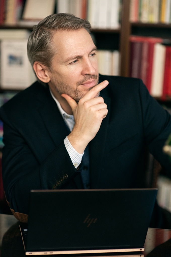 Behandlingschefen Bo Buhrman, sittandes med huvudet i handen i ett bibliotek.