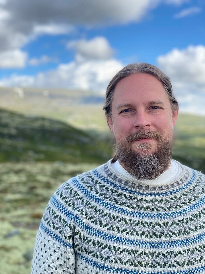Psykologen Stefan Fjellklang i halvfigur, ståendes i ett fjällandskap.