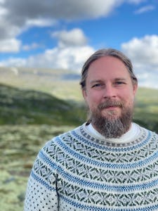Psykologen Stefan Fjellklang i halvfigur, ståendes i ett fjällandskap.