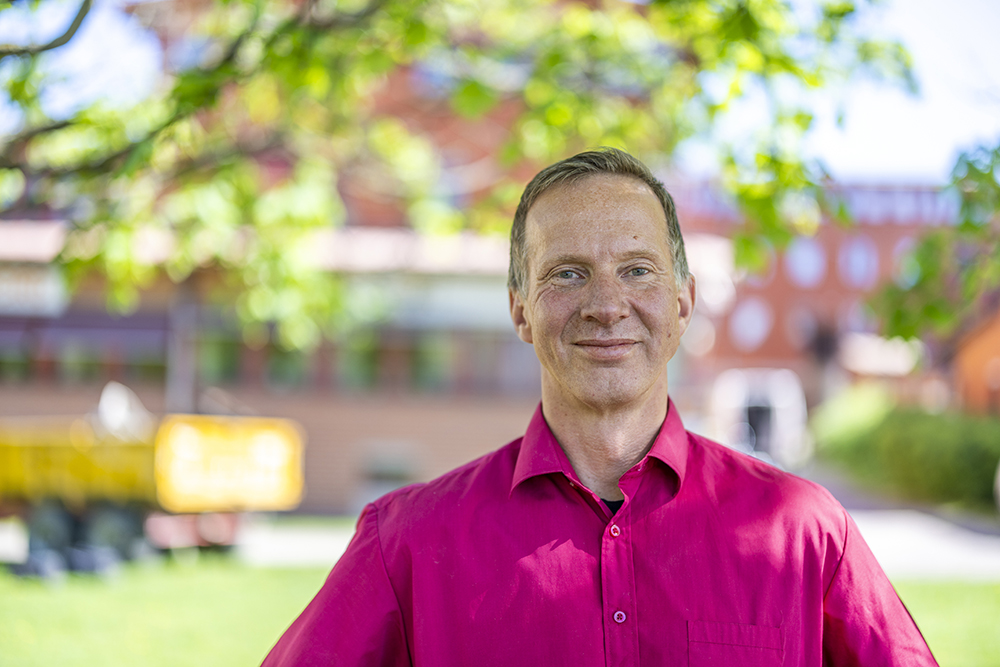 Mats Ädel från frivården i halvprofil ståendes under ett träd.