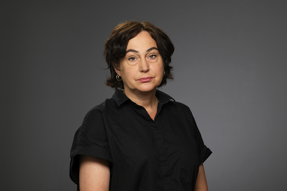 Halvporträtt på Susanne Alm, universitetslektor vid kriminologiska institutionen vid Stockholms universitet, mot neutral bakgrund