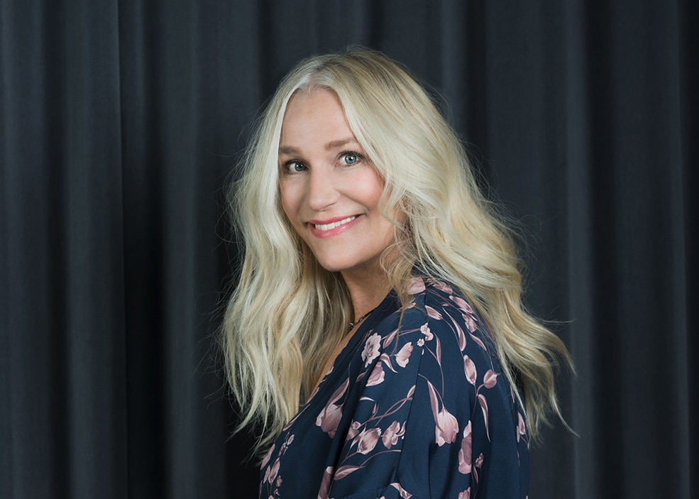 Porträttbild på journalisten Ann Söderlund i halvprofil framför ett svart draperi.