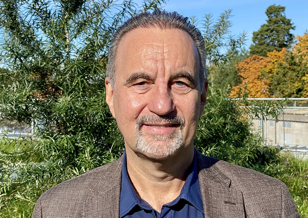Porträttbild på forskaren Björn Phillips i halvprofil, ståendes i en park.
