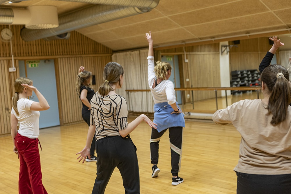 En mindre grupp om fyra personer dansar tillsammans i en danslokal.