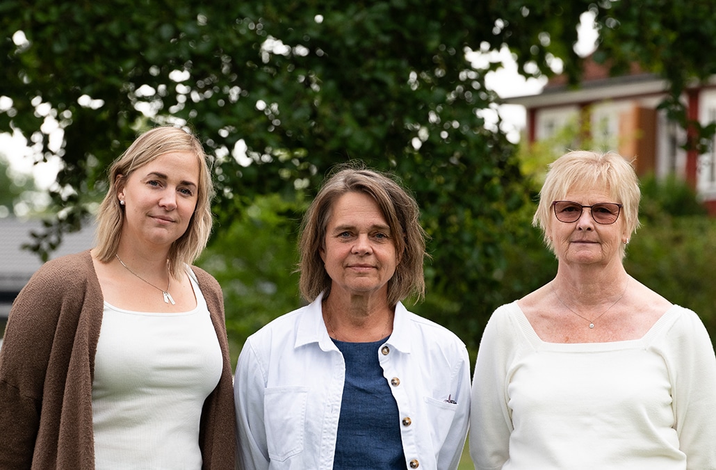 Bild på Moa Lindroos, Susanne Mulder och Vivi Pousar från Stiftelsen Linden, ståendes bredvid varandra i halvprofil framför träd och buskar