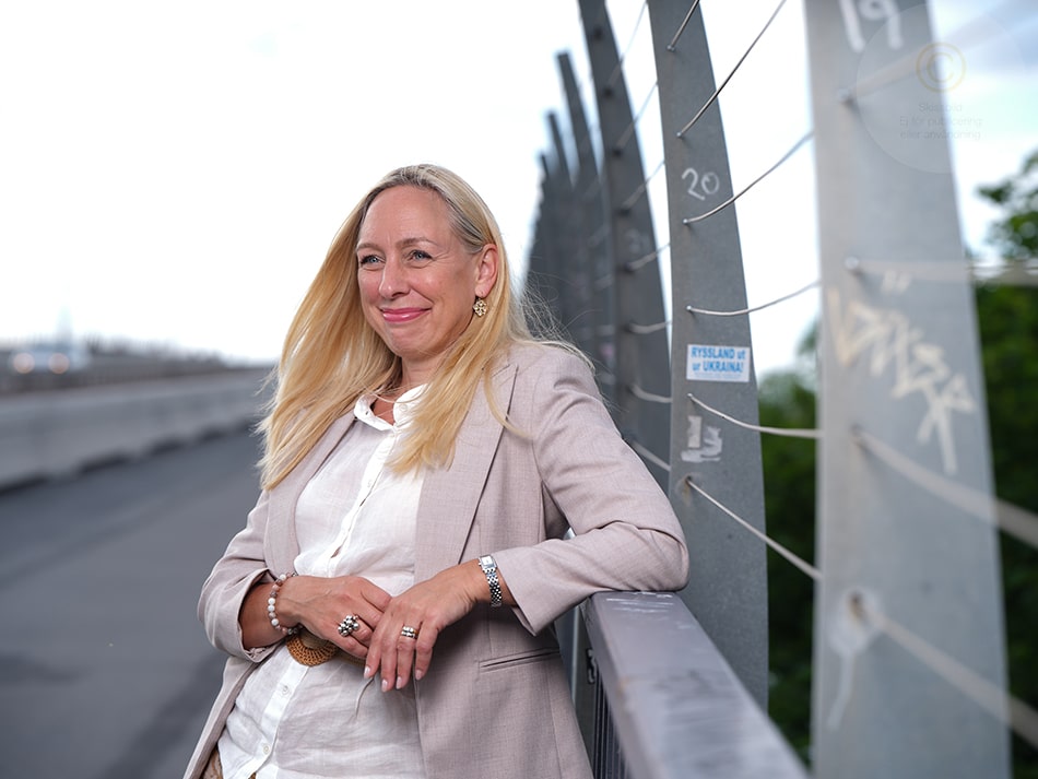 Porträttbild på Anna Sylvén Björnör i halvprofil, ståendes utomhus med en bra bakom sig.