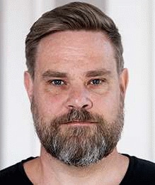 Porträttbild på Johan Lidberg, huvud och axlar, framför en vit bakgrund.