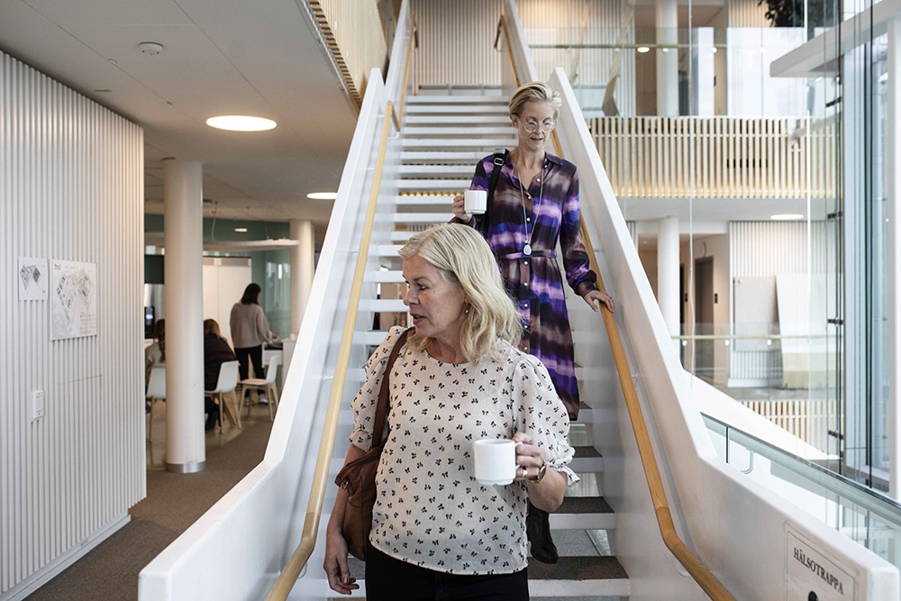 Verksamhetscheferna Elisabeth Svanberg Eriksson och Anna Burston går ner för en trappa.