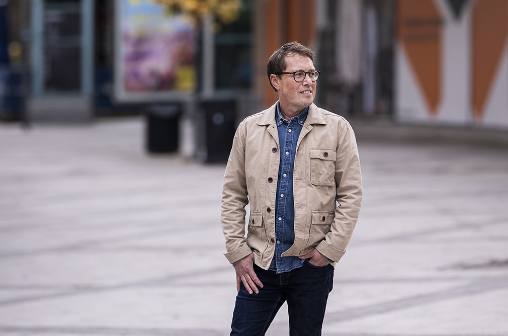 Enhetschefen Mikael Skaghammar står på ett anonymt torg med blicken riktad mot höger.