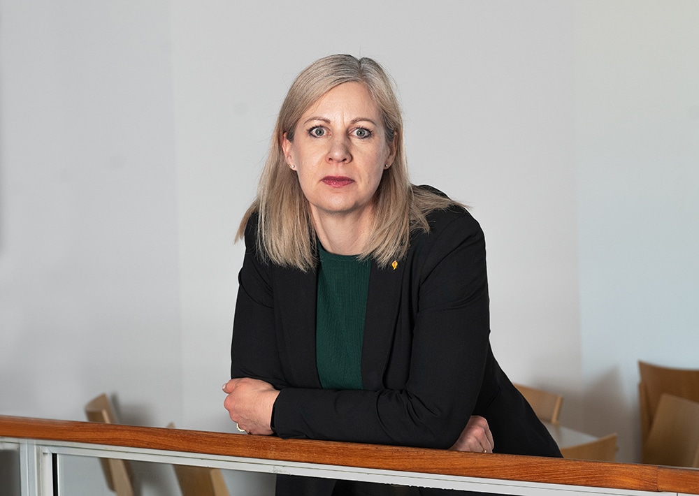 Christina Kiernan i halvprofil, ståendes framåtlutad med armarna vilandes mot ett trappräcke.