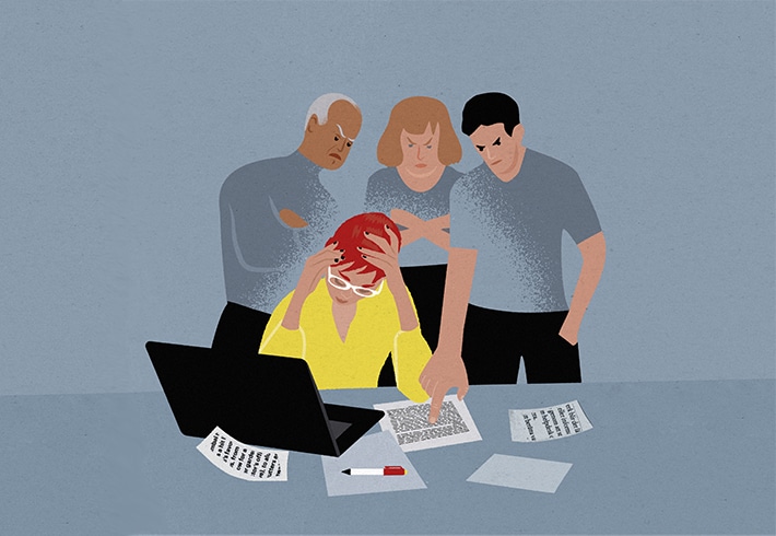Illustration över tre hotfulla kollegor som står lutade över en pressad kollega som sitter med huvudet i händerna vid sitt skrivbord.