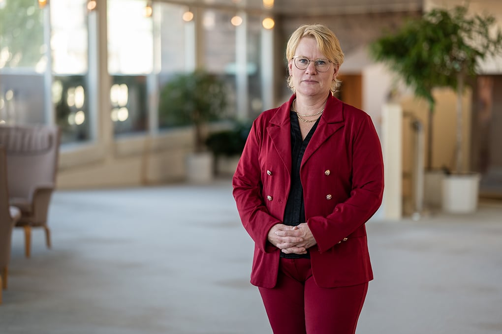 Centerpartiets Martina Johansson, porträtterad i halvprofil, står med blicken riktad mot kameran i vad som ser ut att vara en större lounge.