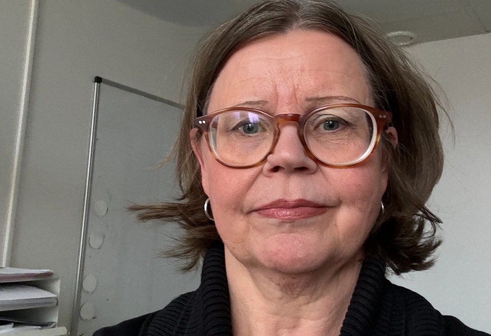 Porträtt på Liselotte Lökken Svärd, huvud och axlar, stående framför en whiteboard-tavla i ett konferensrum.