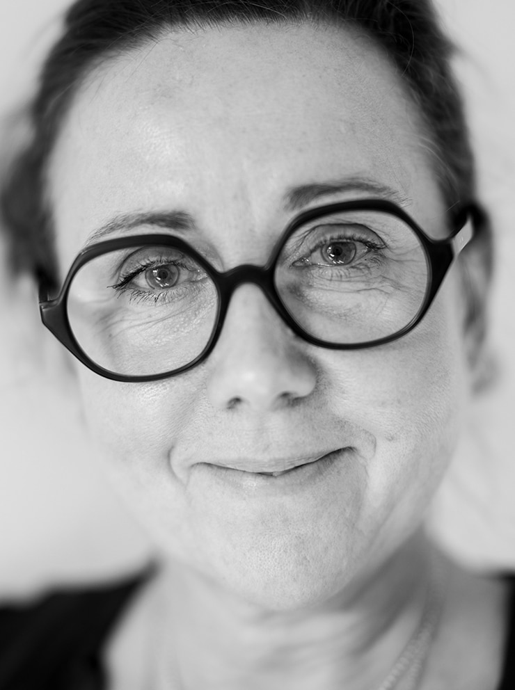 Porträttbild på Susanne Buchmayer i svartvitt, endast huvudet synd, framför en neutral och ljus bakgrund.
