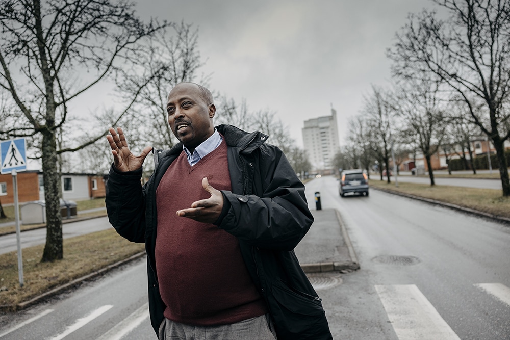 Yusuf Abdow fotograferad i grodperspektiv, ståendes vid ett övergångsställe, i bakgrunden en bil som kör ifrån platsen.