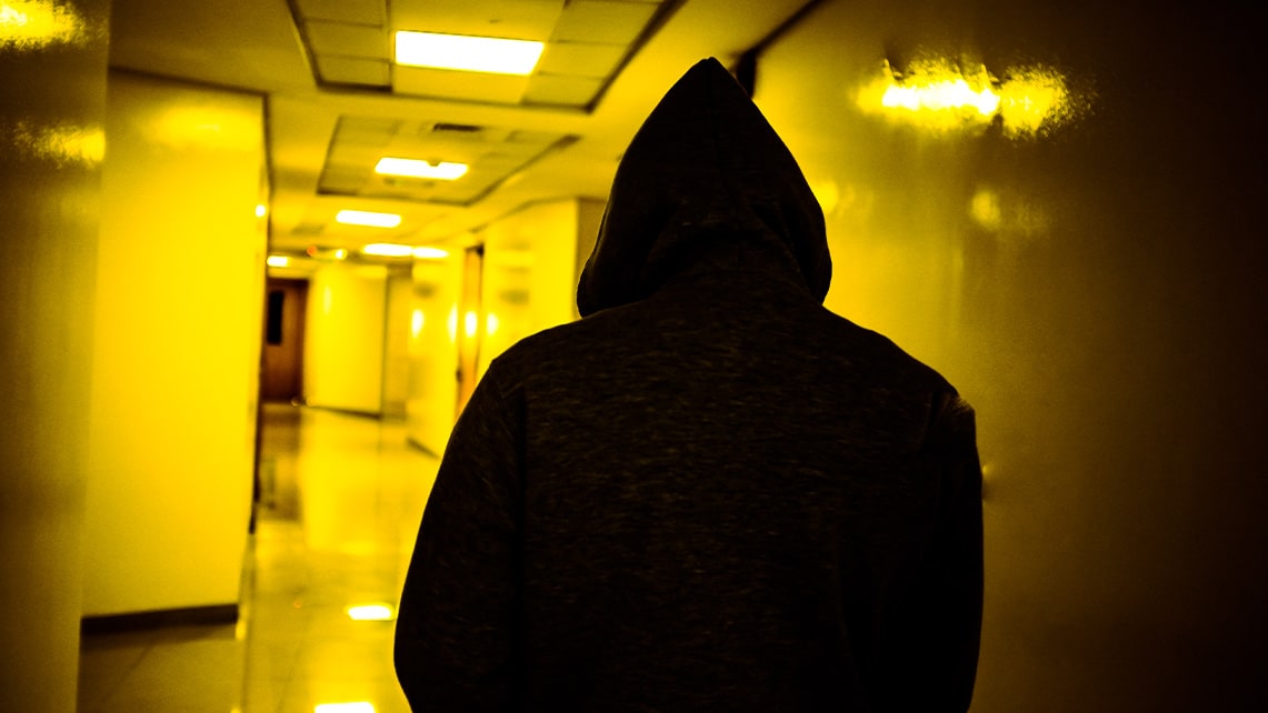 Person med huva spm går genom en steril korridor