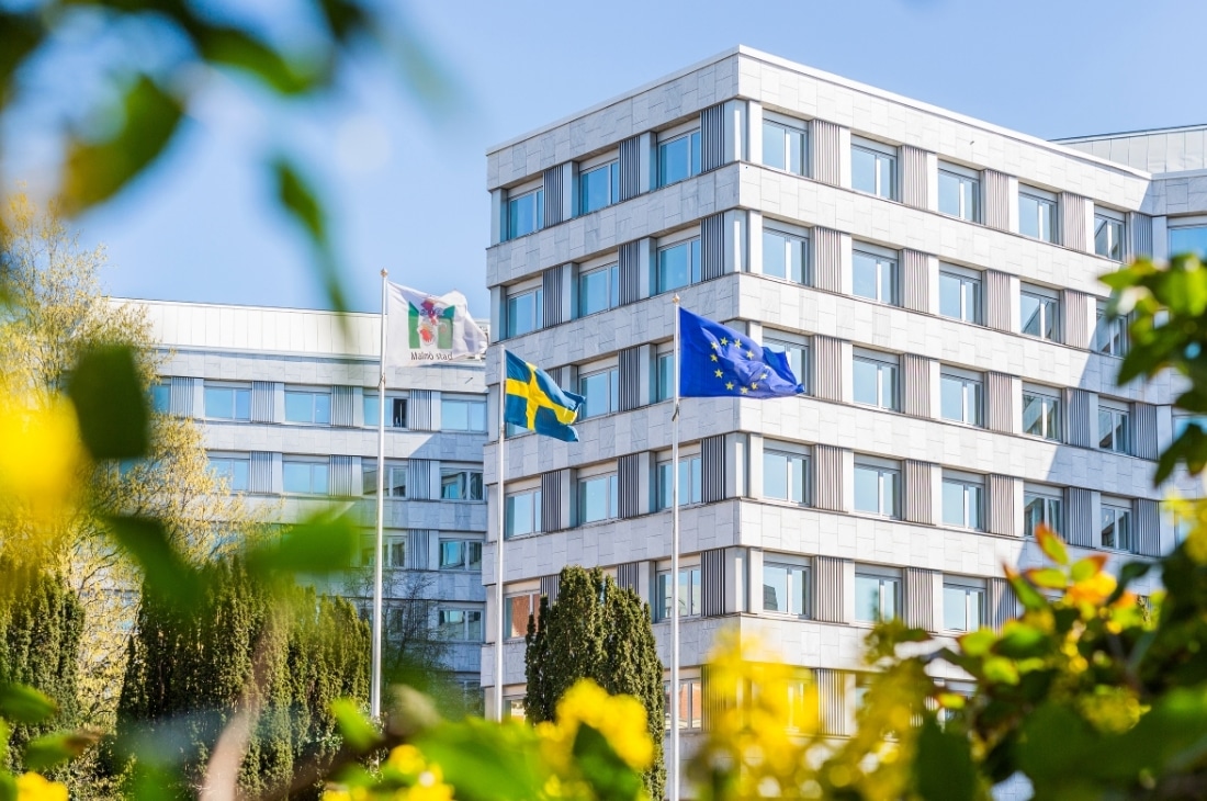 Malmö stads flagga, Sveriges flagga och Europeiska unionens flagga fladdrar utanför stadshuset i Malmö.