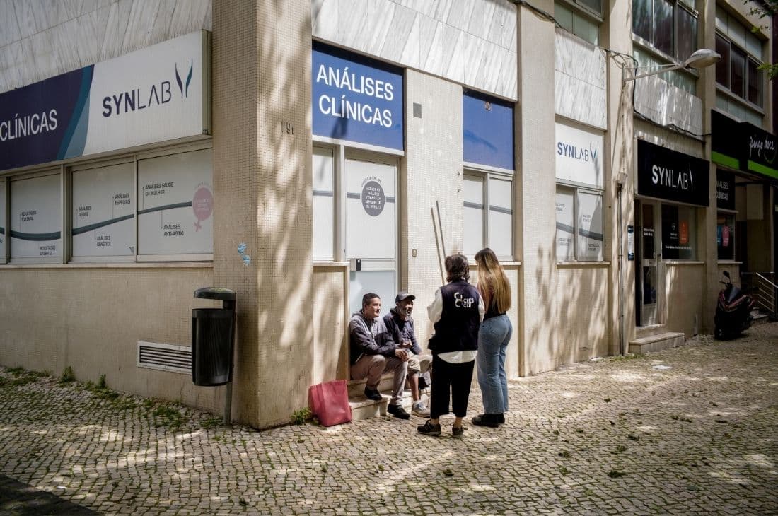 Två personer från Socialtjänsten i Portugal pratar med två personer på en gata.