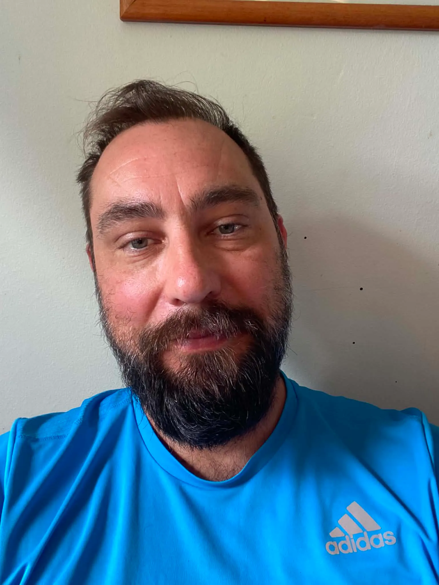Daniel Maroti i en blå Adidas-tröja tittar mot kameran och sitter inomhus framför en ljus vägg.