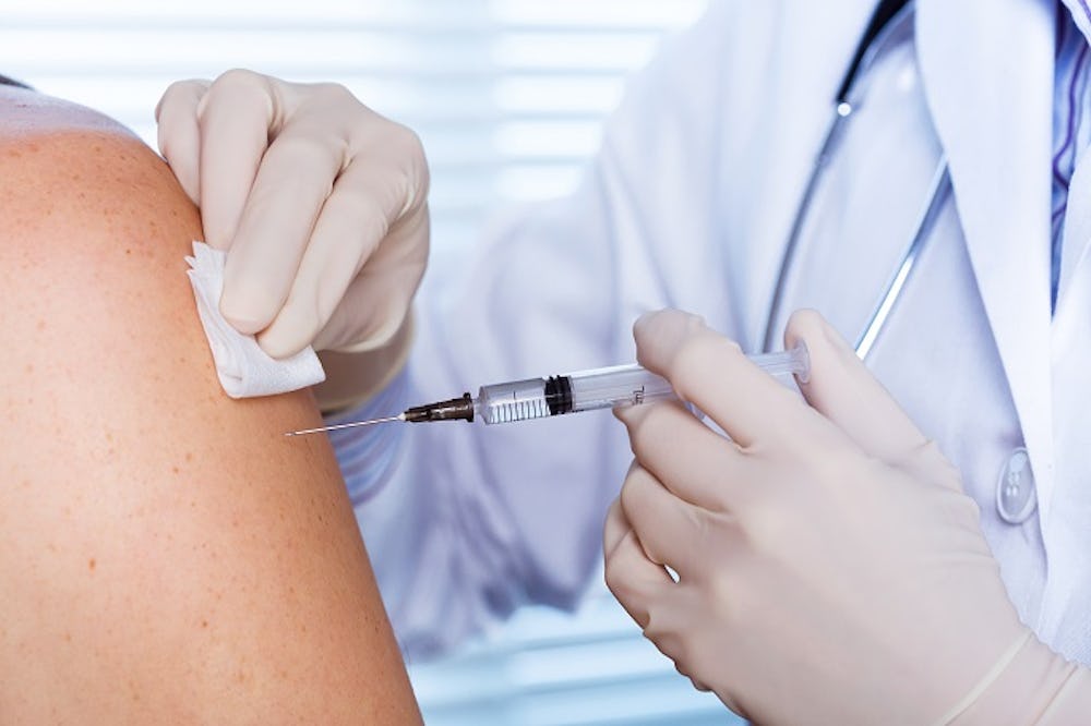 En vaccinspruta sätts i en arm.