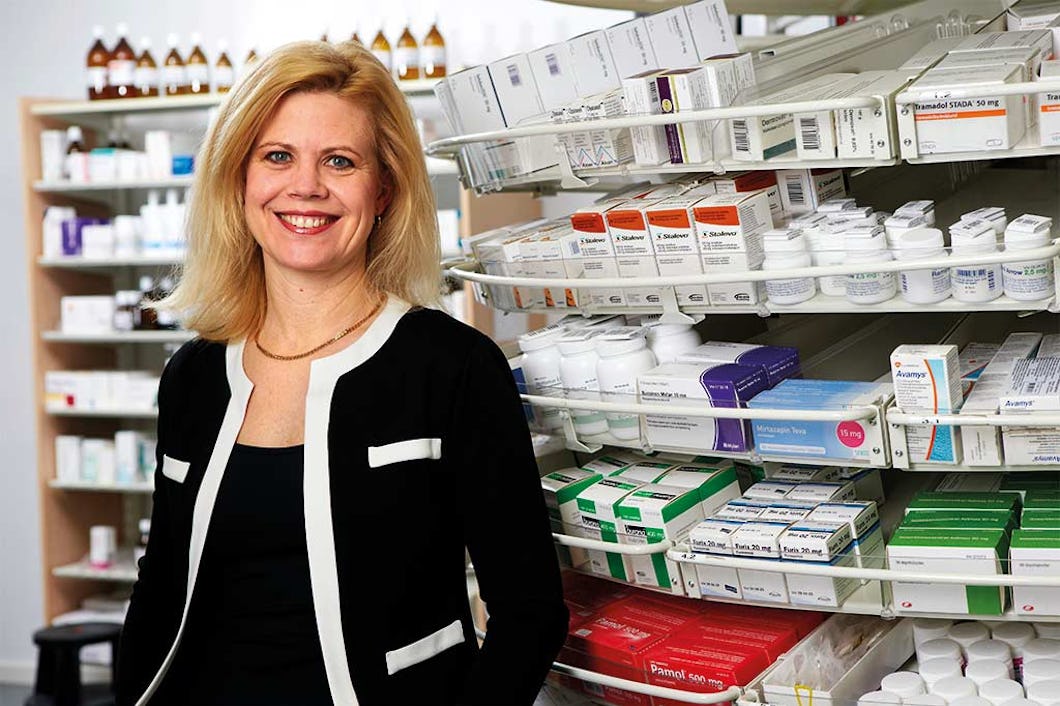 Annika Svedberg står framför en hylla med apoteksprodukter.