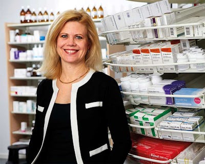 Annika Svedberg står framför en hylla med apoteksprodukter.