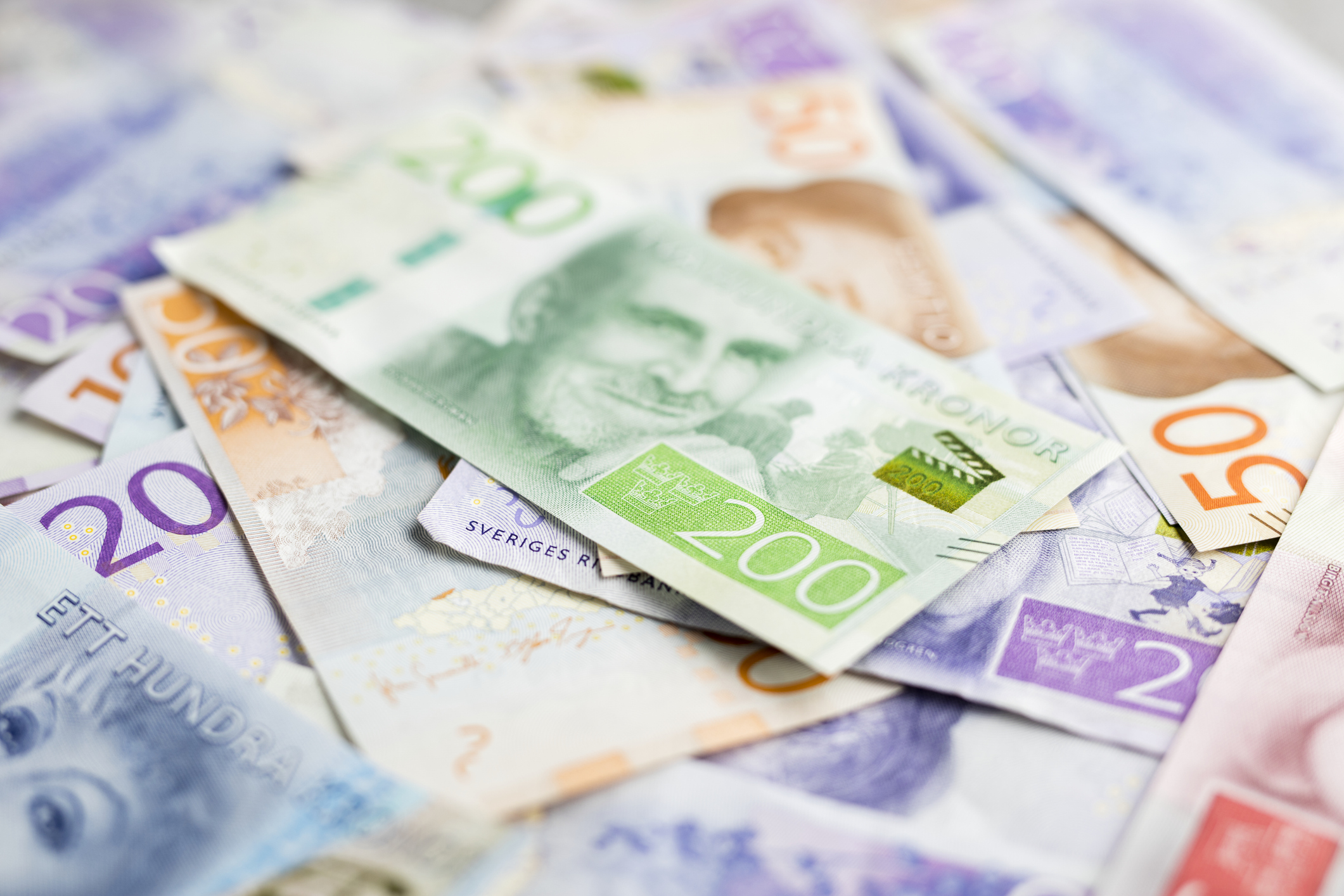 En hög med svenska sedlar i valörerna 200, 100, 50 och 20 kronor ligger utbredda.